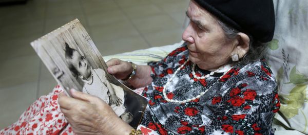 Frecha Amar, 84, from a Moroccan descent, poses with a picture of her baby, who she says was abducted in 1958, on June 29, 2016 at her home in Kfar Chabad, near Tel-Aviv Frecha Amar, 84, from a Moroccan descent, poses with a picture of her baby, who she says was abducted in 1958, on June 29, 2016 at her home in Kfar Chabad, near Tel-Aviv - Sputnik International