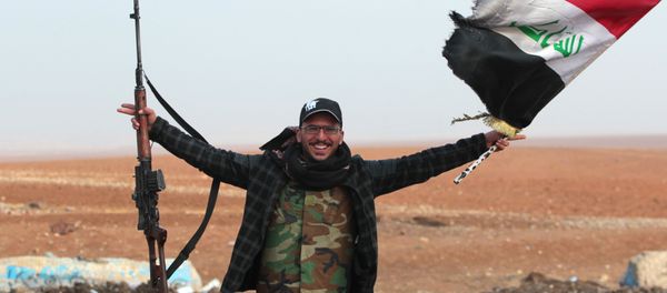 An Iraqi forces member flashes his gun as he waves his national flag in the village of Arabat, south of Mosul, as temperatures continue to drop, on December 1, 2016 An Iraqi forces member flashes his gun as he waves his national flag in the village of Arabat, south of Mosul, as temperatures continue to drop, on December 1, 2016 - Sputnik International