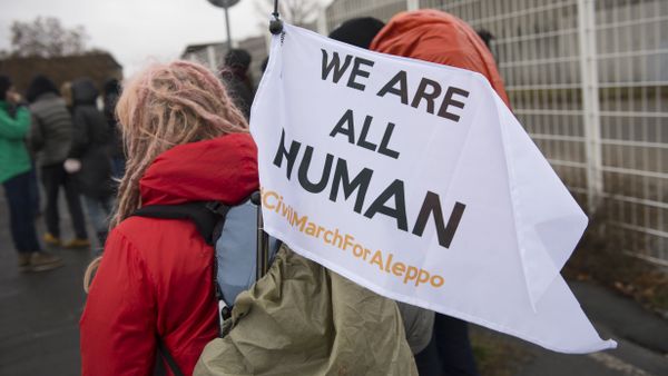 A participant's flag reading 'We are all human' is fixed at a backpack during a solidarity march for Aleppo in Berlin, Germany, on December 26, 2016 - Sputnik International