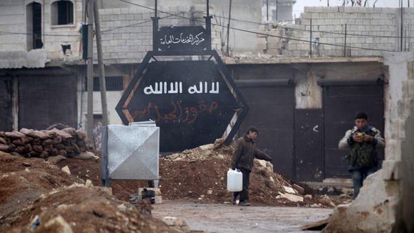 A boy carries a water container near a sign that used to belong to the Islamic State in al-Rai town, northern Aleppo countryside, Syria December 25, 2016 - Sputnik International