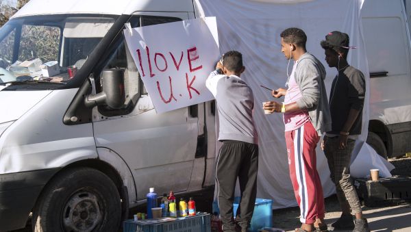 Young migrants paint a sheet of paper with the lettering 'I love UK' in the 'Jungle' migrant camp, in Calais, northern France, on October 31, 2016, during a massive operation to clear the squalid settlement where 6,000-8,000 people have been living in dire conditions Young migrants paint a sheet of paper with the lettering 'I love UK' in the 'Jungle' migrant camp, in Calais, northern France, on October 31, 2016, during a massive operation to clear the squalid settlement where 6,000-8,000 people have been living in dire conditions - Sputnik International