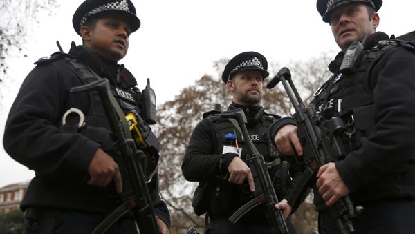 Armed police officers patrol a closed road during the Changing of the Guard ceremony at Buckingham Palace in London - Sputnik International
