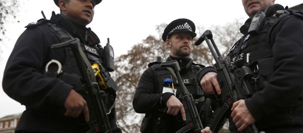 Armed police officers patrol a closed road during the Changing of the Guard ceremony at Buckingham Palace in London - Sputnik International