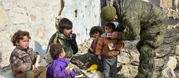Military engineers of the Russian Army's international counter-mine center are seen in an Aleppo street with children. File photo - Sputnik International