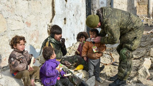 Military engineers of the Russian Army's international counter-mine center who continue the demining operation in eastern Aleppo, Syria are seen here in an Aleppo street with children - Sputnik International