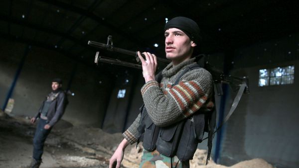 A rebel fighter carries his weapon inside a damaged building on the forth day of the truce, on al-Rayhan village front near the rebel held besieged city of Douma, in the eastern Damascus suburb of Ghouta, Syria January 2, 2017 - Sputnik International