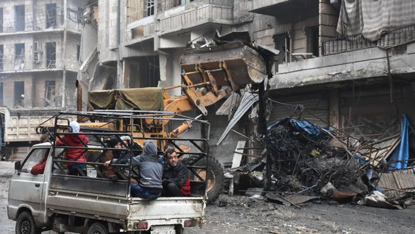 Syrian civilians drive past a tractor removing rubble as the Syrian government starts to clean up areas formerly held by opposition forces in the northern city of Aleppo on December 27, 2016, in the Shaar district. Syrian civilians drive past a tractor removing rubble as the Syrian government starts to clean up areas formerly held by opposition forces in the northern city of Aleppo on December 27, 2016, in the Shaar district. - Sputnik International