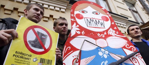 Protesters hold an angry Matryoshka with a weapon and placard reading Boycott Russia ! during an action in central Kiev, on April 9, 2014, calling for the boycott of Russian goods - Sputnik International