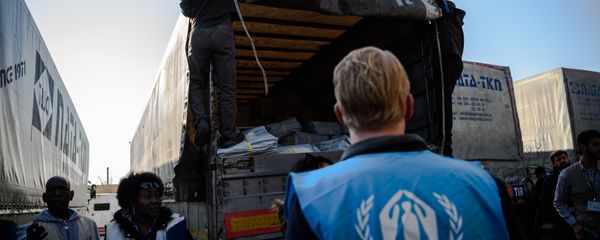 A UNHCR worker stands as workers carry humanitarian aid to a Syrian-bound truck at a UN transhipment hub at Cilvegozu in Reyhanli near the Turkish-Syrian border in Hatay on November 28, 2016 A UNHCR worker stands as workers carry humanitarian aid to a Syrian-bound truck at a UN transhipment hub at Cilvegozu in Reyhanli near the Turkish-Syrian border in Hatay on November 28, 2016 - Sputnik International
