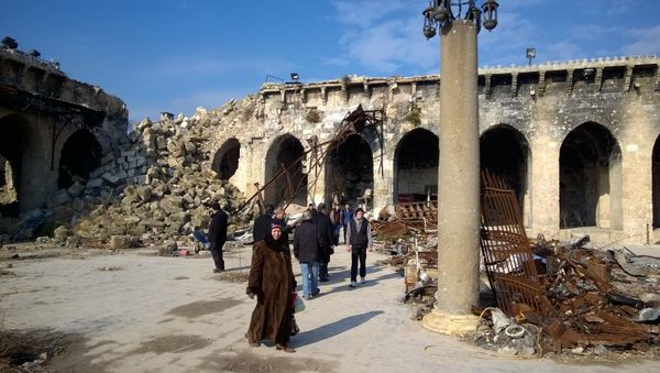 Citizens at a yard of the Umayyad Mosque of Aleppo destroyed following military actions. The Umayyad Mosque was the largest and the oldest mosque of Aleppo - Sputnik International