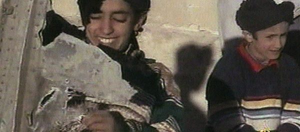 In this image made from video broadcast by the Qatari-based satellite television station Al-Jazeera Wednesday, Nov. 7, 2001, a young boy, left, identified as Hamza bin Laden holds what the Taliban says is a piece of U.S. helicopter wreckage in Ghazni, Afghanistan on Monday, Nov. 5, 2001 - Sputnik International
