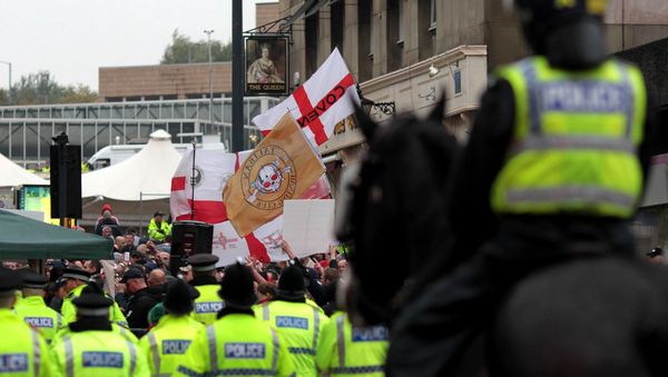 Police officers stand guard as members of the English Defence League (EDL) demonstrate on Bridge Street in Bradford city centre, west Yorkshire, on October 12, 2013. Police officers stand guard as members of the English Defence League (EDL) demonstrate on Bridge Street in Bradford city centre, west Yorkshire, on October 12, 2013. - Sputnik International
