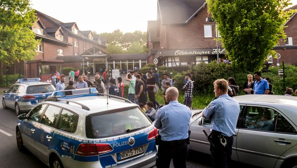In this May 21, 2016 picture police and refugees stand near a refugee shelter in Bielefeld, Germany In this May 21, 2016 picture police and refugees stand near a refugee shelter in Bielefeld, Germany - Sputnik International