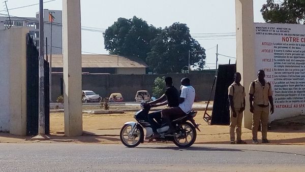 A man rides a motorcycle while two soldiers stand in front of the prefecture of police in Bouake on January 6, 2017 - Sputnik International