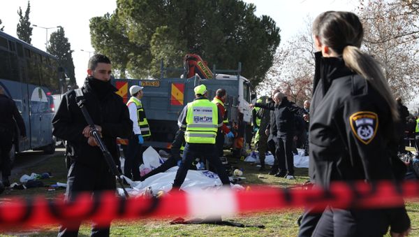 Israeli Zaka volunteers examine a body of one of the four Israeli soldiers killed when a Palestinian truck driver ran into the group at the Jerusalem promenade - Sputnik International