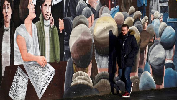 A man walks past a mural on the Falls Road a day after Northern Ireland's Deputy First Minister Martin McGuinness resigned, throwing the devolved joint administration into crisis, in Belfast Northern Ireland, January 10, 2017. A man walks past a mural on the Falls Road a day after Northern Ireland's Deputy First Minister Martin McGuinness resigned, throwing the devolved joint administration into crisis, in Belfast Northern Ireland, January 10, 2017. - Sputnik International