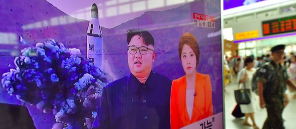 A South Korean soldier (R) walks past a television screen reporting news of North Korea's latest submarine-launched ballistic missile test at a railway station in Seoul on August 25, 2016 - Sputnik International