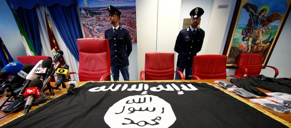 Police officers stand next to a black Islamic State flag that was seized in a raid, at a news conference held at the police headquarters in Rome, Italy, January 10, 2017 - Sputnik International