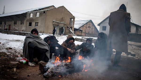 Migrants warm up around a fire at a makeshift shelter at an abandoned warehouse in Belgrade on January 10, 2017, as temperatures dropped to -15 degrees Celsius overnight Migrants warm up around a fire at a makeshift shelter at an abandoned warehouse in Belgrade on January 10, 2017, as temperatures dropped to -15 degrees Celsius overnight - Sputnik International