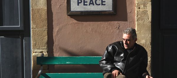 A man sits on a bench under a peace sign near the UN-controlled buffer zone in Nicosia, Cyprus January 9, 2017. A man sits on a bench under a peace sign near the UN-controlled buffer zone in Nicosia, Cyprus January 9, 2017. - Sputnik International