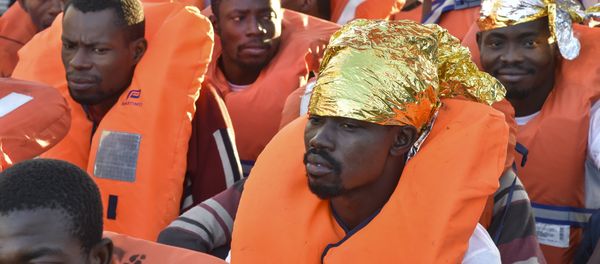 Migrants and refugees wait to be trasferred from the Topaz Responder ship run by Maltese NGO Moas and the Italian Red Cross to the Vos Hestia ship run by NGO Save the Children, on November 4, 2016, a day after a rescue operation off the Libyan coast in the Mediterranean Sea. Migrants and refugees wait to be trasferred from the Topaz Responder ship run by Maltese NGO Moas and the Italian Red Cross to the Vos Hestia ship run by NGO Save the Children, on November 4, 2016, a day after a rescue operation off the Libyan coast in the Mediterranean Sea. - Sputnik International