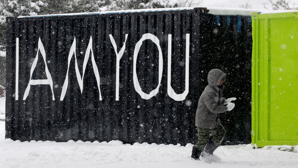 A stranded Syrian refugee boy walks through a snow storm at a refugee camp north of Athens, Greece January 10, 2017. - Sputnik International