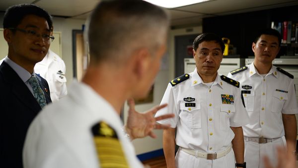 Capt. Kyle P. Higgins, commanding officer of the U.S. 7th Fleet flagship USS Blue Ridge, conducts a ship tour with Vice Adm. Jinlong Shen of the People's Liberation Army Navy. - Sputnik International