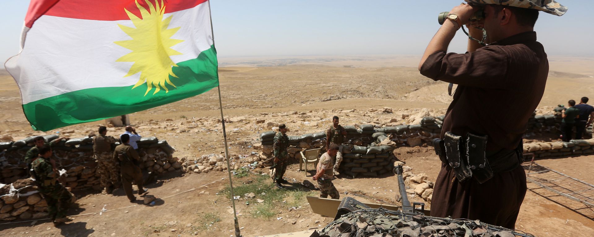 A flag of the autonomous Kurdistan region flies as Iraqi Kurdish Peshmerga fighters take position to monitor the area from their front line post in Bashiqa, a town 13 kilometres north-east of Mosul (File) A flag of the autonomous Kurdistan region flies as Iraqi Kurdish Peshmerga fighters take position to monitor the area from their front line post in Bashiqa, a town 13 kilometres north-east of Mosul (File) - Sputnik International, 1920, 26.10.2023