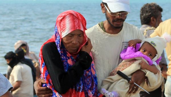 Yemenis walk on a beach of Aden's Tawahi neighbourhood on May 6, 2015 as civilians are trying to escape by sea the ongoing fighting. - Sputnik International