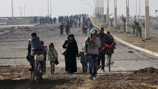 Civilians move away as Iraqi security forces fight against Islamic State militants on the eastern side of Mosul, Iraq, Wednesday, Jan. 18, 2017 - Sputnik International
