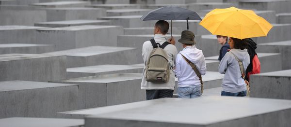 Tourists with umbrellas walk through the Holocaust Memorial on July 28, 2011 in Berlin. - Sputnik International