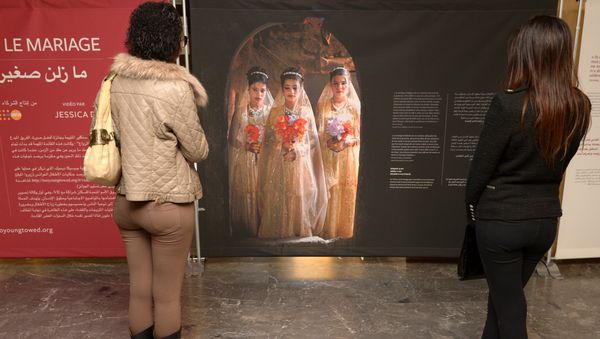 Moroccan women look at photographs of under-age brides during an exhibition by Stephanie Sinclair at the Mohammed V theatre in Rabat on December 4, 2013 Moroccan women look at photographs of under-age brides during an exhibition by Stephanie Sinclair at the Mohammed V theatre in Rabat on December 4, 2013 - Sputnik International