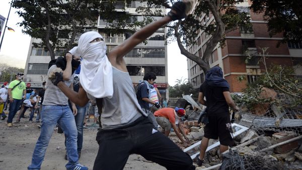 Opposition activists throw stones against National Guard members during a protest in Caracas (File) Opposition activists throw stones against National Guard members during a protest in Caracas (File) - Sputnik International