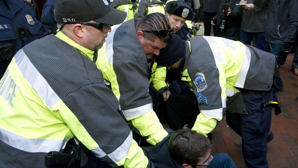 Police try to remove a demonstrator from attempting to block people entering a security checkpoint, Friday, Jan. 20, 2017, ahead of President-elect Donald Trump's inauguration in Washington Police try to remove a demonstrator from attempting to block people entering a security checkpoint, Friday, Jan. 20, 2017, ahead of President-elect Donald Trump's inauguration in Washington - Sputnik International
