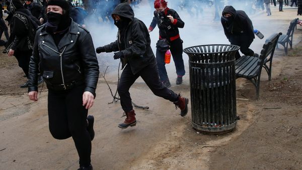 Activists race after being hit by a stun grenade while protesting against U.S. President-elect Donald Trump on the sidelines of the inauguration in Washington, U.S., January 20, 2017. Activists race after being hit by a stun grenade while protesting against U.S. President-elect Donald Trump on the sidelines of the inauguration in Washington, U.S., January 20, 2017. - Sputnik International