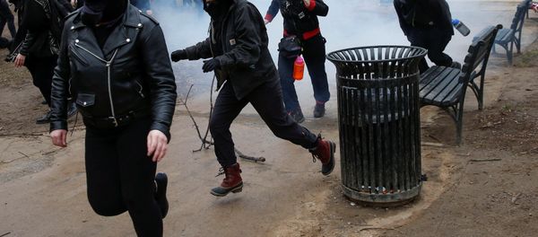Activists race after being hit by a stun grenade while protesting against U.S. President-elect Donald Trump on the sidelines of the inauguration in Washington, U.S., January 20, 2017. - Sputnik International