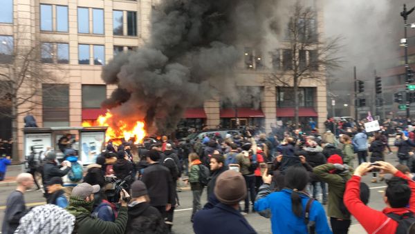 A car set aflame by anti-Trump protesters. A car set aflame by anti-Trump protesters. - Sputnik International