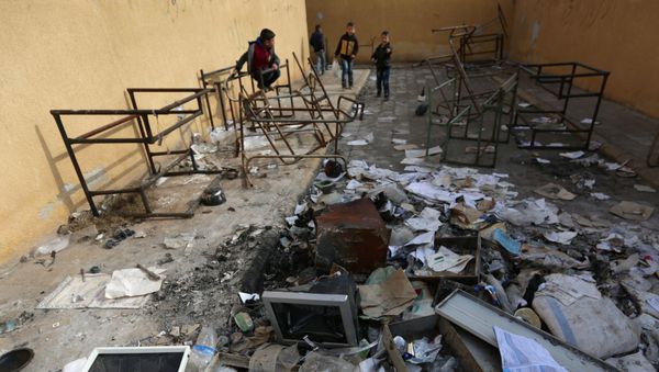 Students stand amid damaged desks and books in 'Aisha Mother of the BelieversÕ school which was recently reopened after rebels took control of al-Rai town from Islamic State militants, Syria January 17, 2017 - Sputnik International