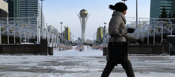 A picture taken on January 22, 2017 shows a woman walking in downtown Astana, with the Baiterek monument seen in the background A picture taken on January 22, 2017 shows a woman walking in downtown Astana, with the Baiterek monument seen in the background - Sputnik International
