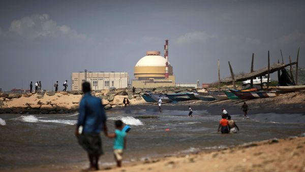 A fisherman and his son stand near the Russian-built Kudankulam Atomic Power Project, at Kudankulam, about 700 kilometers (440 miles) south of Chennai, Tamil Nadu state, India, Thursday, Sept. 13, 2012 - Sputnik International