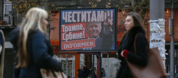 Pedestrians walk by a billboard picturing US President-elect Donald Trump with an inscrpition that translates as Congratulations! Trump, Serb! published by Serbian daily newspaper in Belgrade on November 10, 2016 - Sputnik International