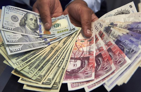 This file photo taken on October 04, 2016 shows a cashier displaying multiple denomination US dollar and British pound Sterling bank notes for a photograph inside a currency exchange store in central London on October 4, 2016. This file photo taken on October 04, 2016 shows a cashier displaying multiple denomination US dollar and British pound Sterling bank notes for a photograph inside a currency exchange store in central London on October 4, 2016. - Sputnik International
