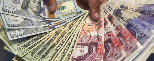 This file photo taken on October 04, 2016 shows a cashier displaying multiple denomination US dollar and British pound Sterling bank notes for a photograph inside a currency exchange store in central London on October 4, 2016. This file photo taken on October 04, 2016 shows a cashier displaying multiple denomination US dollar and British pound Sterling bank notes for a photograph inside a currency exchange store in central London on October 4, 2016. - Sputnik International