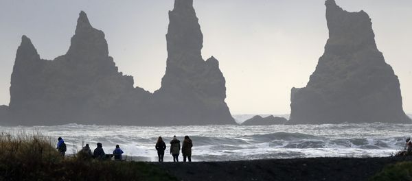 People walk on the black sanded beach in Vik, Iceland, near the Volcano Katla - Sputnik International