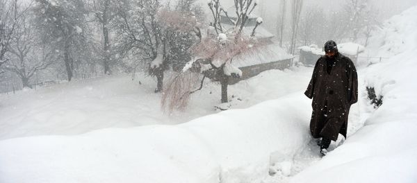 An Indian Kashmiri villager walks through snow in Gund, some 70km northeast from Srinagar An Indian Kashmiri villager walks through snow in Gund, some 70km northeast from Srinagar - Sputnik International