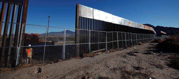 A worker stands next to a newly built section of the U.S.-Mexico border fence at Sunland Park, U.S. opposite the Mexican border city of Ciudad Juarez, Mexico A worker stands next to a newly built section of the U.S.-Mexico border fence at Sunland Park, U.S. opposite the Mexican border city of Ciudad Juarez, Mexico - Sputnik International