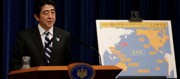 Japan's Prime Minister Shinzo Abe speaks next to a map showing participating countries in rule-making negotiations for the Trans-Pacific Partnership (TPP) during a news conference at his official residence in Tokyo (File) - Sputnik International