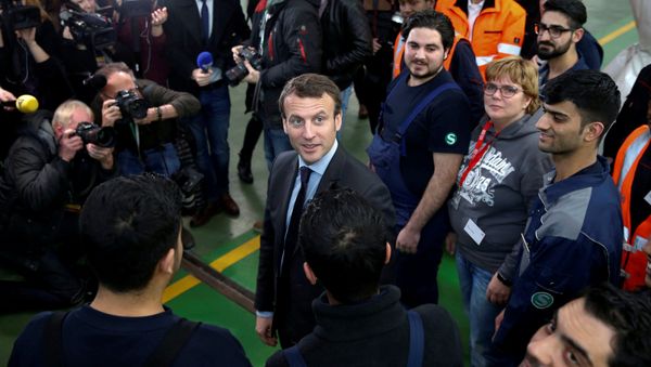 Emmanuel Macron (C), head of the political movement En Marche !, or Forward !, and candidate for the 2017 French presidential election, smiles during a visit to a qualification class for refugees of German railway operator Deutsche Bahn in Berlin, Germany January 10, 2017 Emmanuel Macron (C), head of the political movement En Marche !, or Forward !, and candidate for the 2017 French presidential election, smiles during a visit to a qualification class for refugees of German railway operator Deutsche Bahn in Berlin, Germany January 10, 2017 - Sputnik International