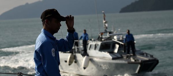 A Royal Malaysian Navy sailor (L) gestures as he stands aboard a naval ship during a search and rescue mission for boat-people, near the Thai-Malaysia border north of Langkawi island on May 28, 2015 - Sputnik International