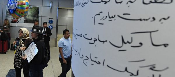 Silvia Sadjadi (L) who migrated from Iran, waits for a family member to arrive beside a arabic sign,after the immigration ban imposed by U.S Silvia Sadjadi (L) who migrated from Iran, waits for a family member to arrive beside a arabic sign,after the immigration ban imposed by U.S - Sputnik International